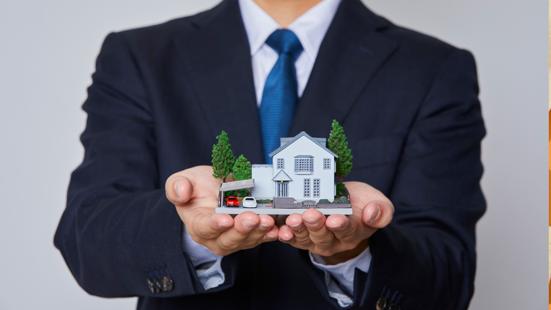 Businessman holding a miniature house in his hands, symbolizing real estate investment and home ownership.