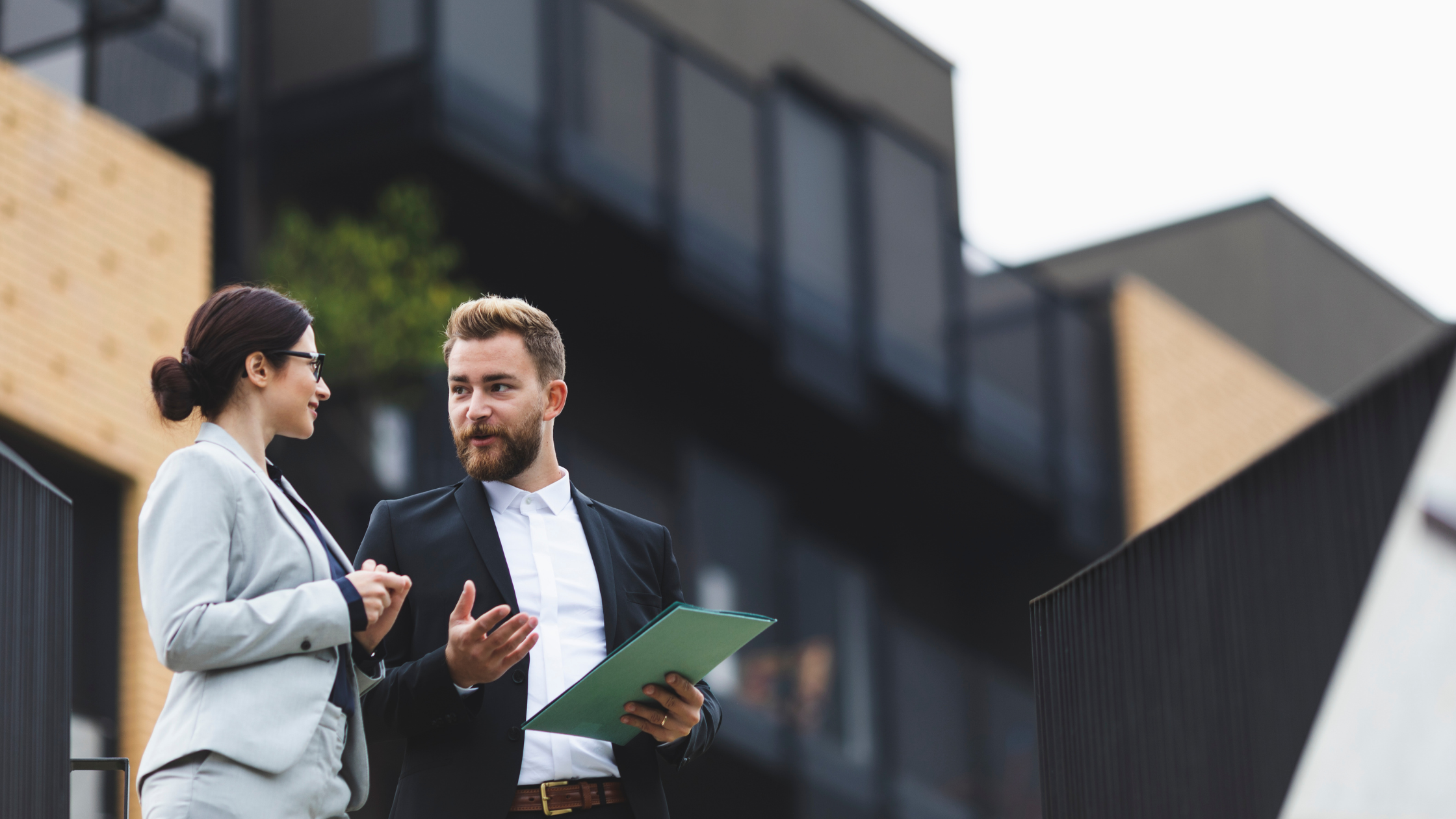 Annual checkup illustration showing two business professionals reviewing documents outside an office building, representing preventive healthcare planning and health insurance guidance.