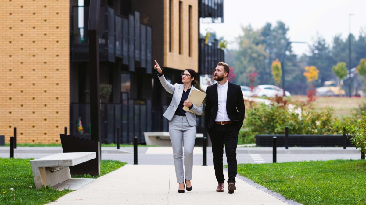 Real estate professionals walking through a modern residential development, representing strategic property investment, property portfolio growth, and identifying investment opportunities in the Australian property market.