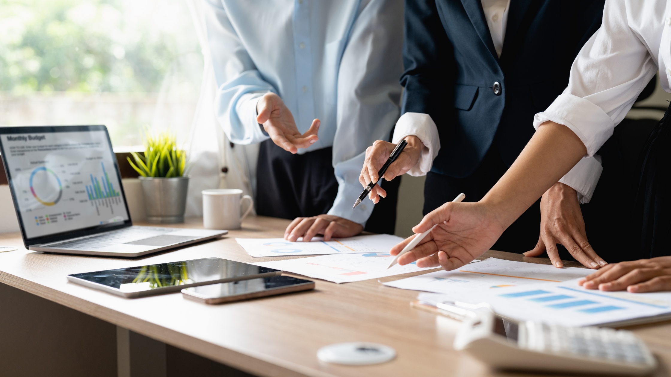 Property investment professionals reviewing plans, financial documents, and market data during a strategy meeting, representing portfolio planning, investment analysis, and long-term property investment decision-making in Australia.